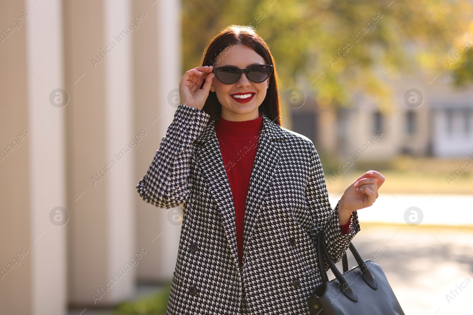 Photo of Portrait of smiling businesswoman in stylish suit outdoors