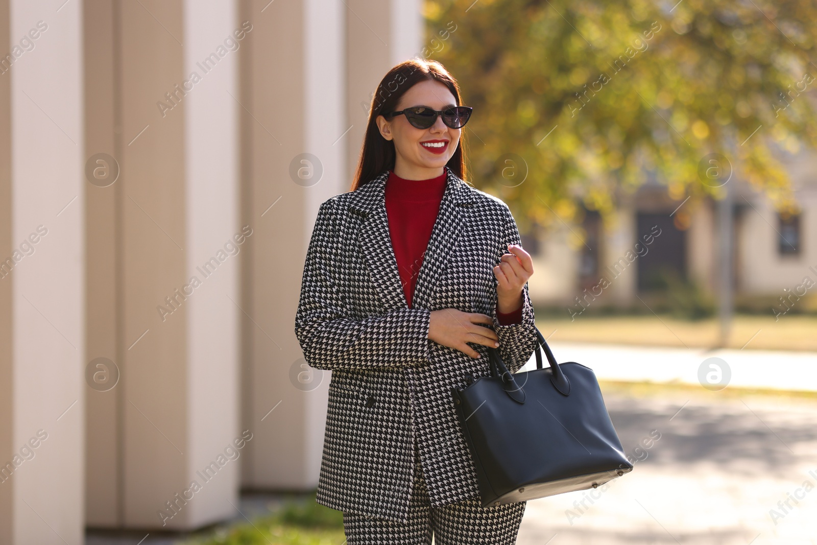 Photo of Portrait of smiling businesswoman in stylish suit outdoors