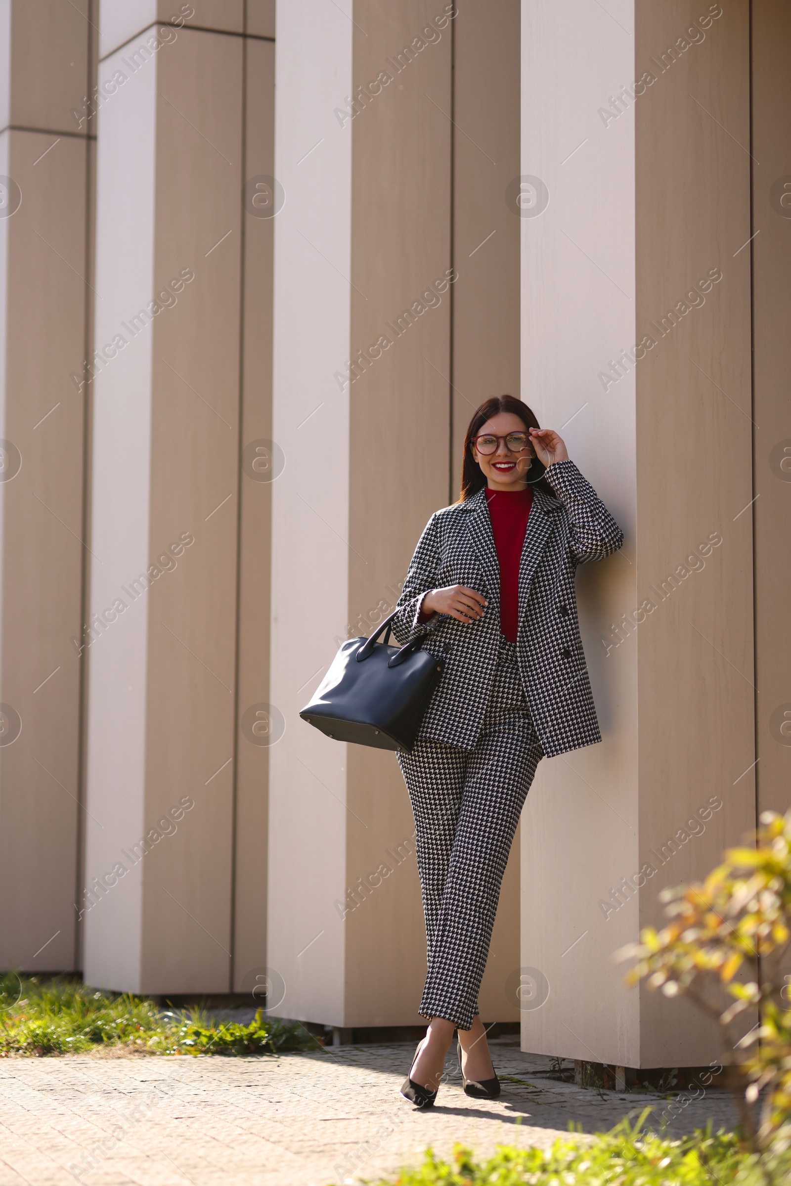 Photo of Smiling businesswoman in stylish suit outdoors on sunny day