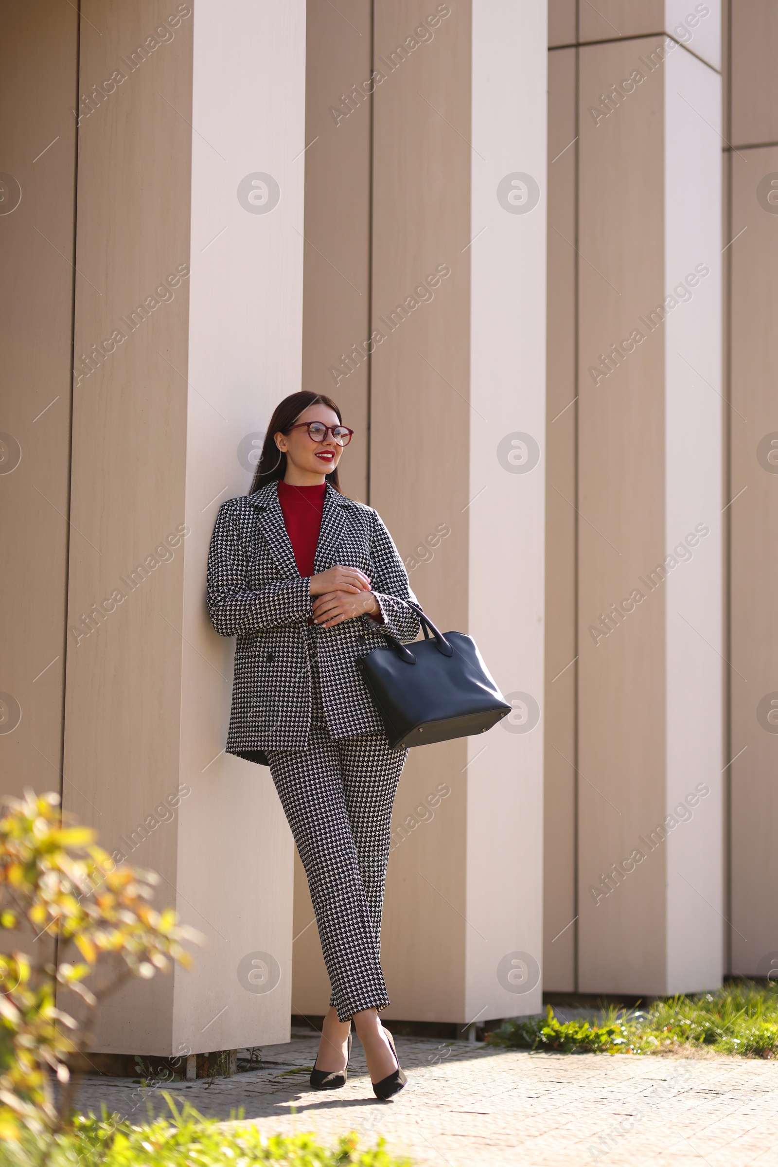 Photo of Smiling businesswoman in stylish suit outdoors on sunny day