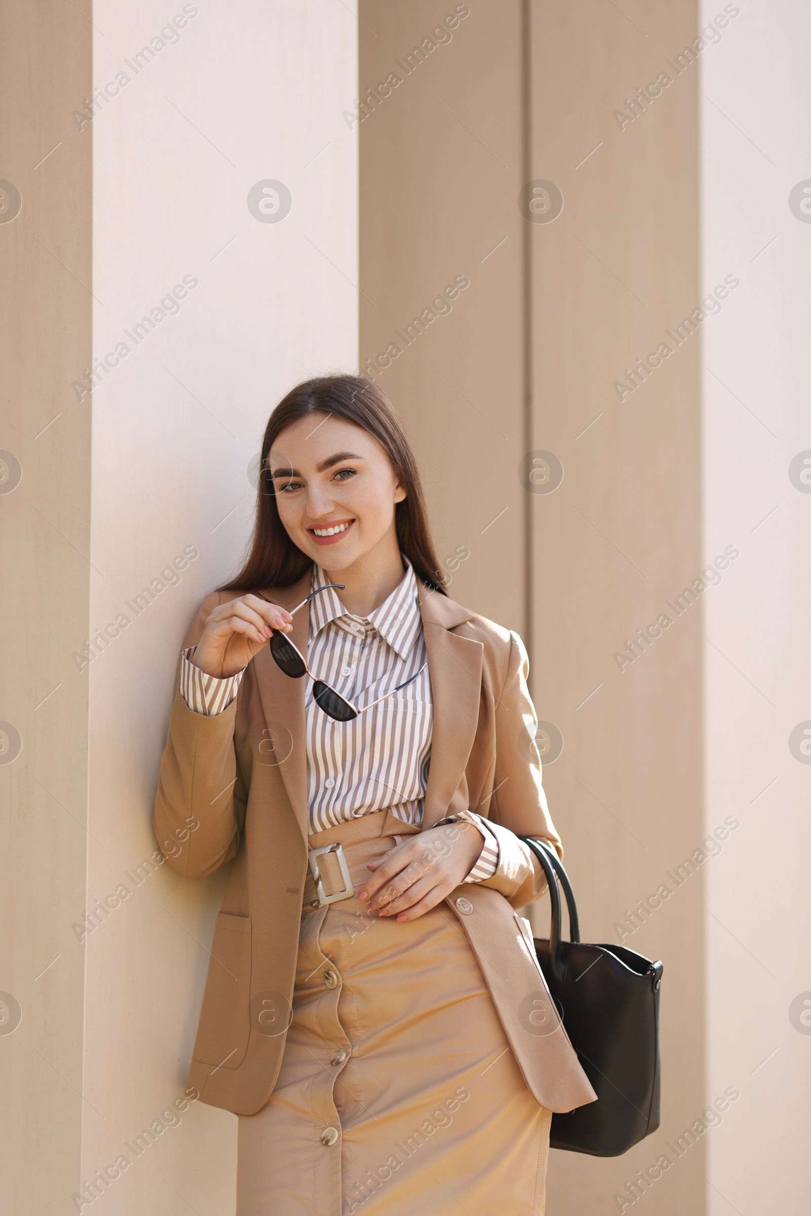 Photo of Portrait of smiling businesswoman in stylish suit outdoors