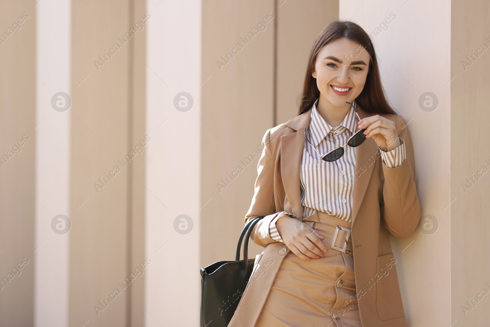 Photo of Beautiful woman in stylish suit outdoors. Space for text