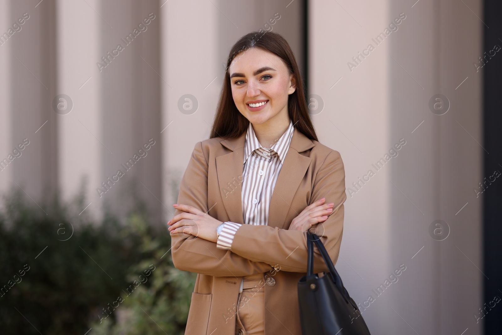 Photo of Portrait of smiling businesswoman in stylish suit outdoors