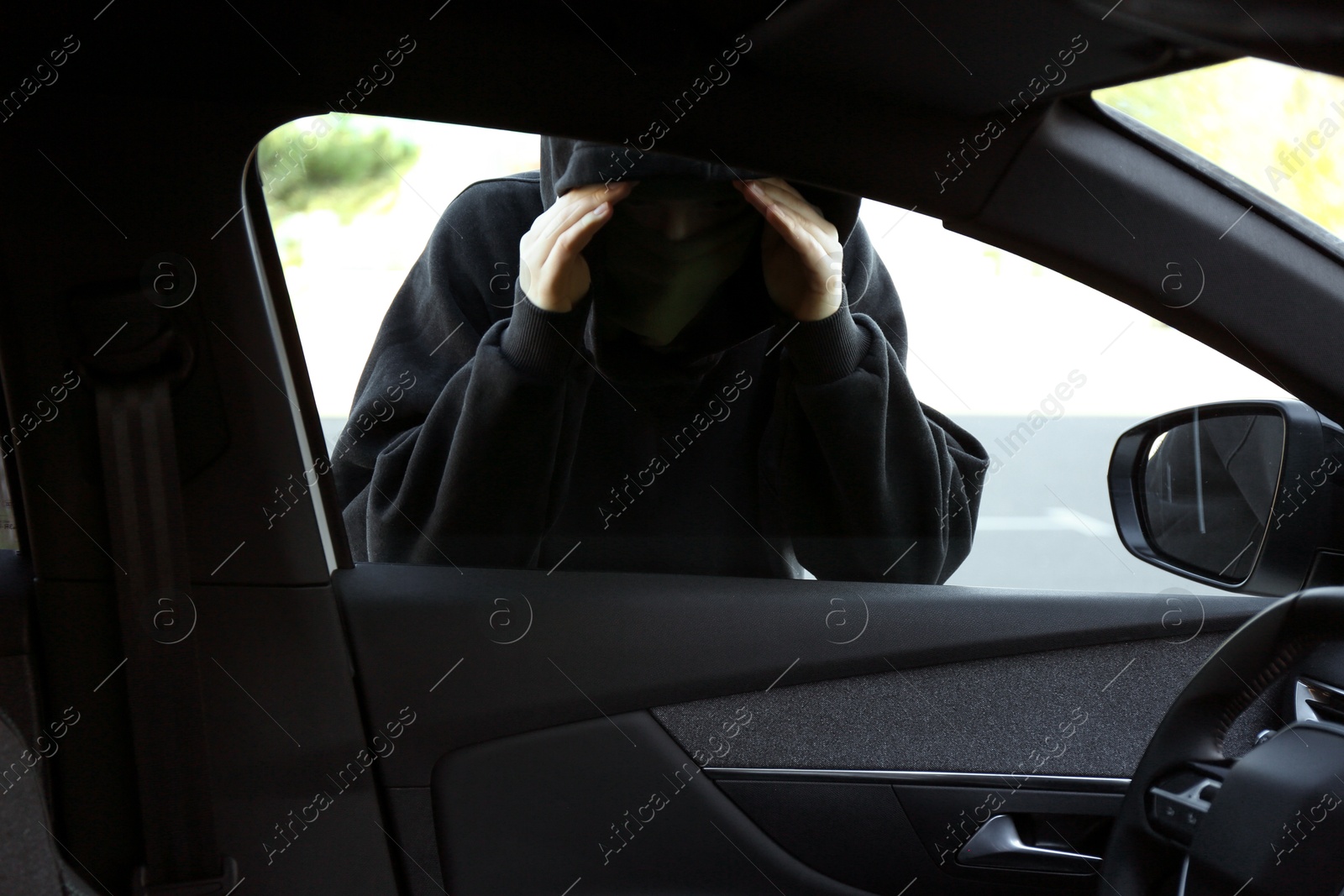 Photo of Thief looking into car through side window