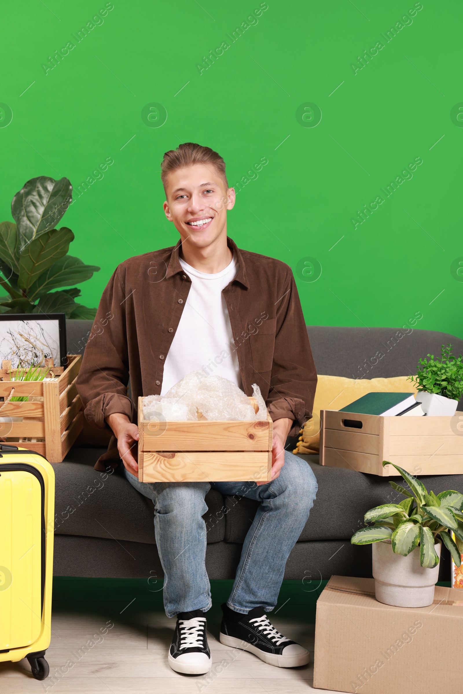 Photo of Happy man with different stuff in new apartment. Housewarming party