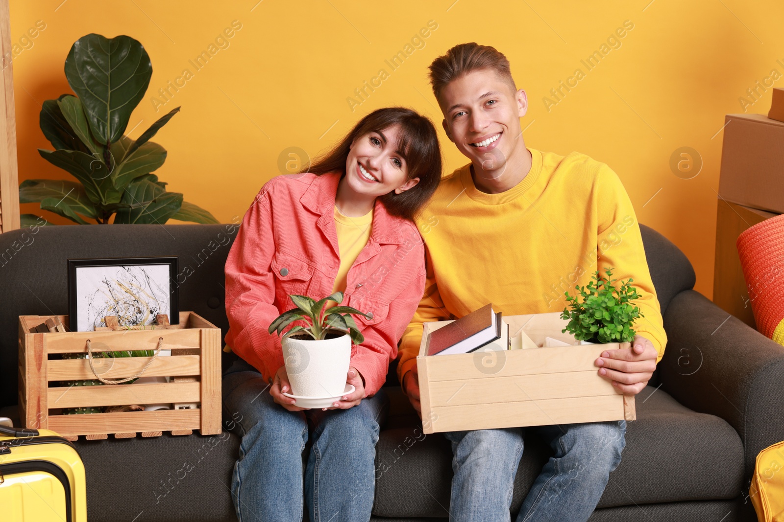 Photo of Happy couple with different stuff in new apartment. Housewarming party