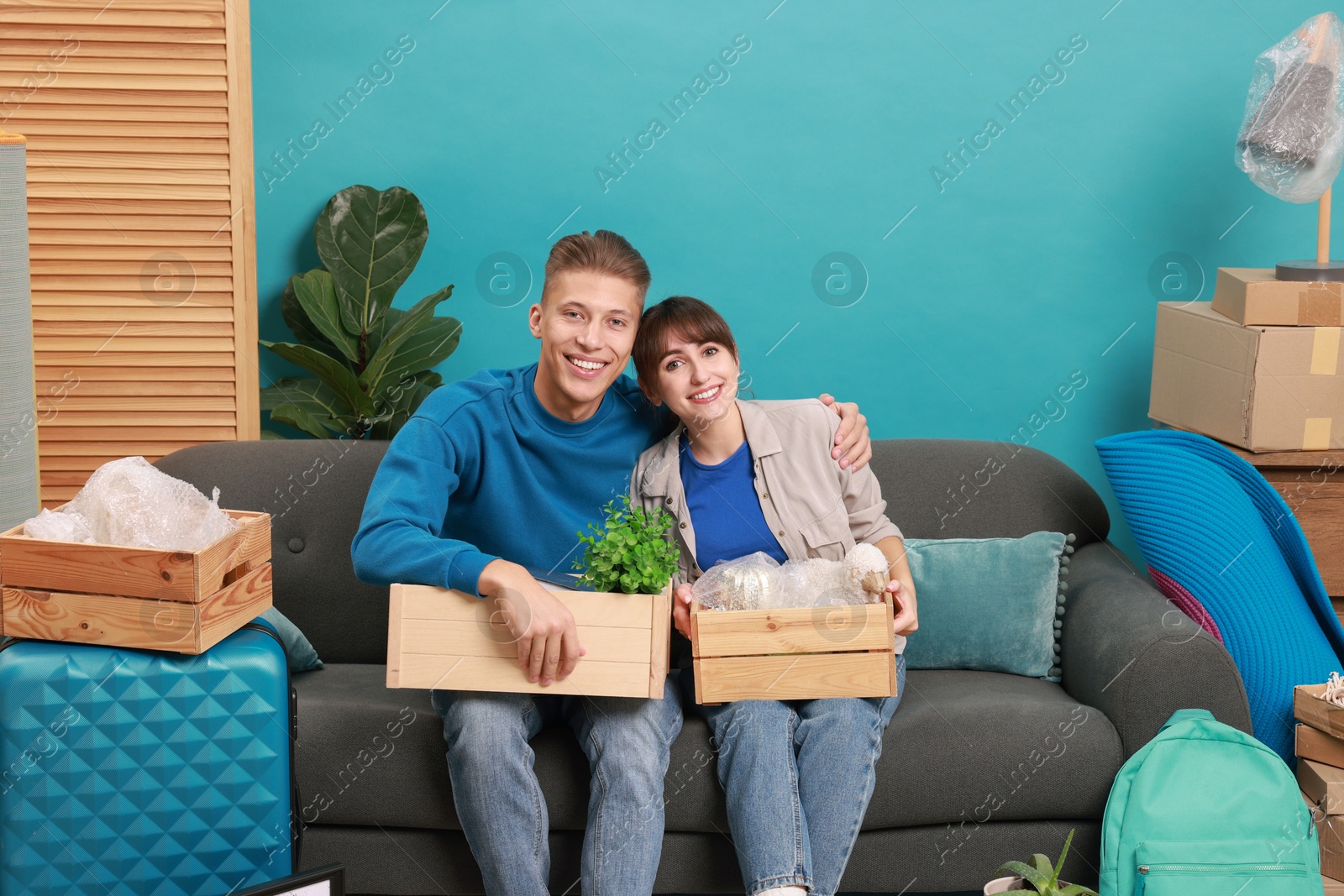 Photo of Happy couple with different stuff in new apartment. Housewarming party