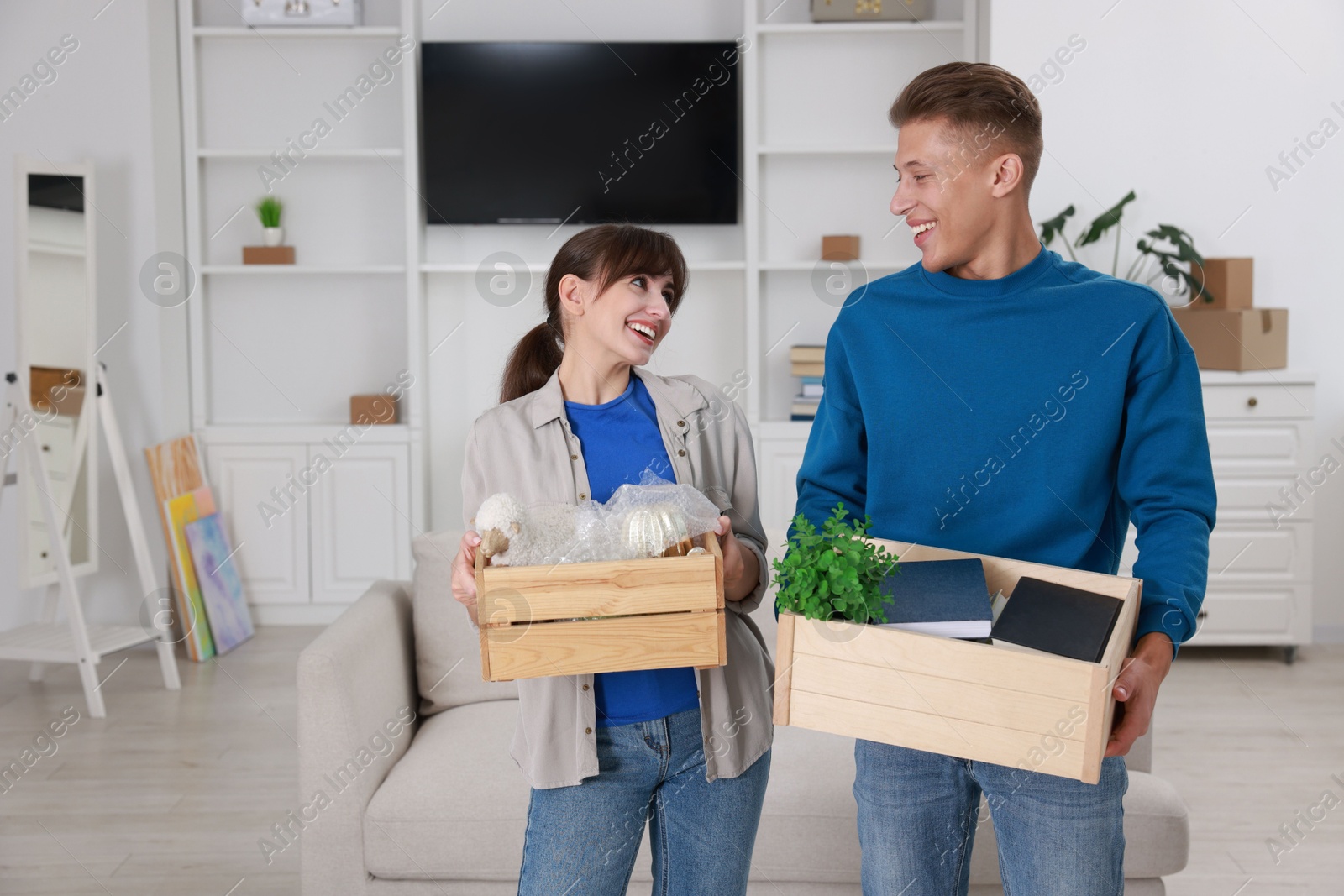 Photo of Happy couple with different stuff in new apartment. Housewarming party