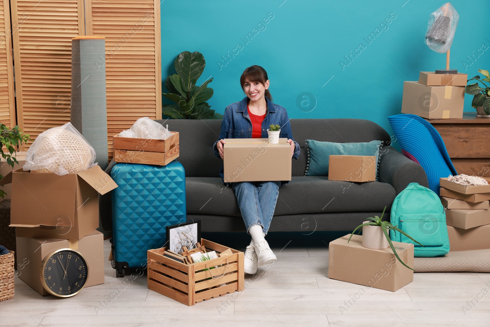 Photo of Happy woman with different stuff in new apartment. Housewarming party