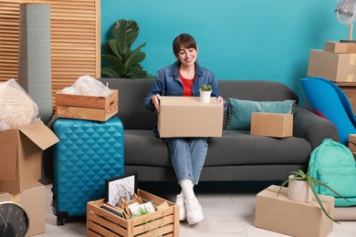 Happy woman with different stuff in new apartment. Housewarming party