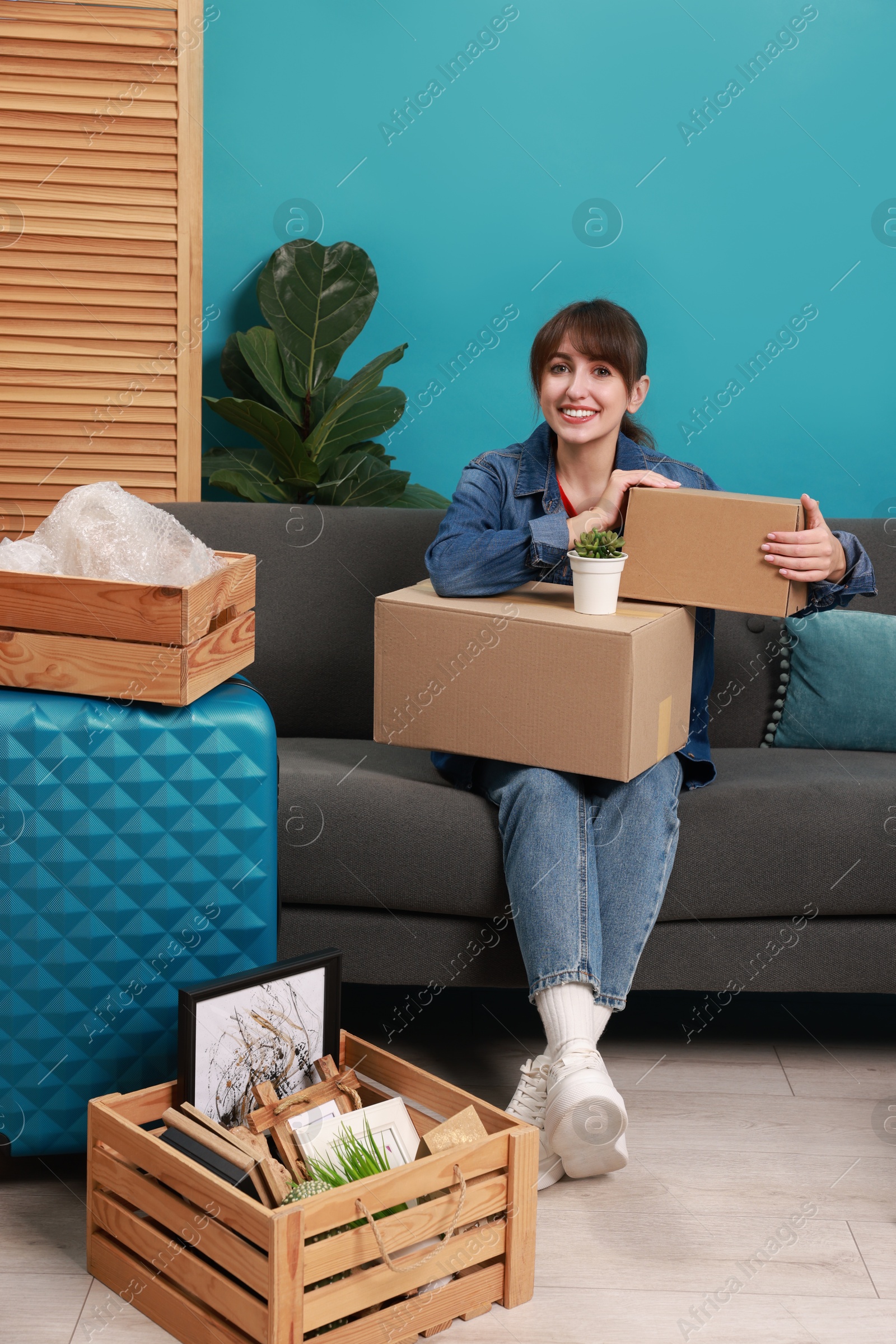 Photo of Happy woman with different stuff in new apartment. Housewarming party