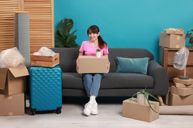 Happy woman with different stuff in new apartment. Housewarming party