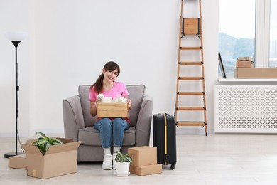 Happy woman with different stuff in new apartment. Housewarming party