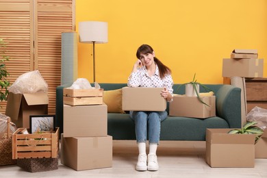 Photo of Happy woman with moving boxes in new apartment. Housewarming party