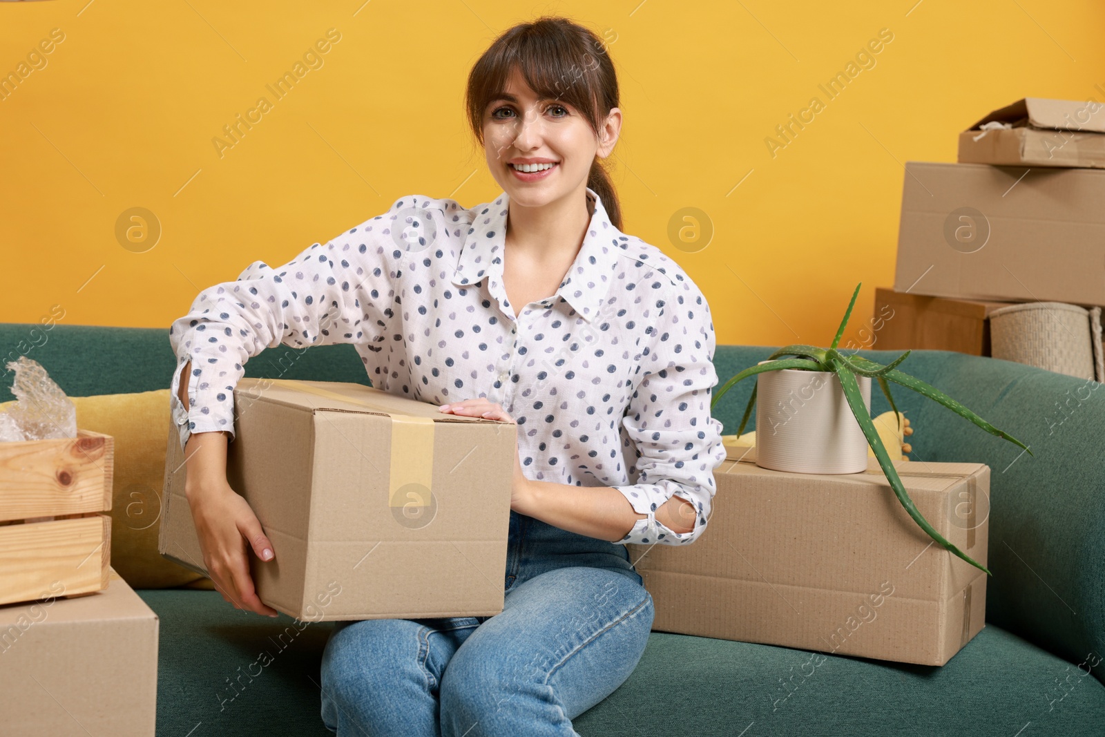 Photo of Happy woman with moving boxes in new apartment. Housewarming party