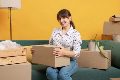 Photo of Happy woman with moving boxes in new apartment. Housewarming party