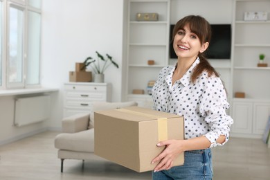 Happy woman with moving box in new apartment. Housewarming party