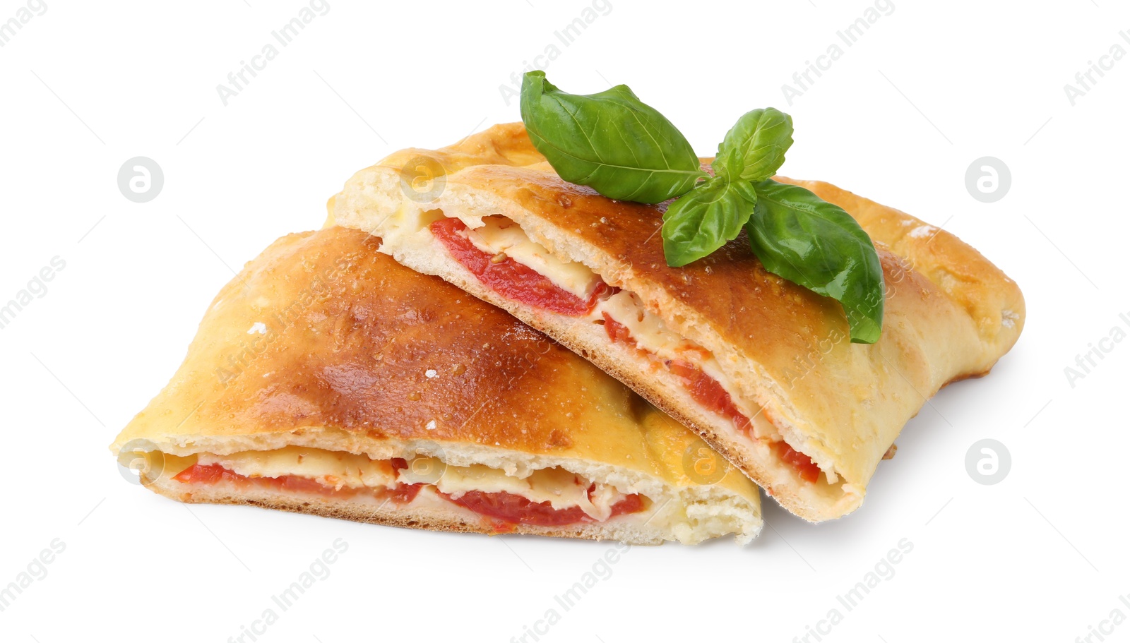 Photo of Pieces of tasty vegetarian calzone with tomato, cheese and basil isolated on white