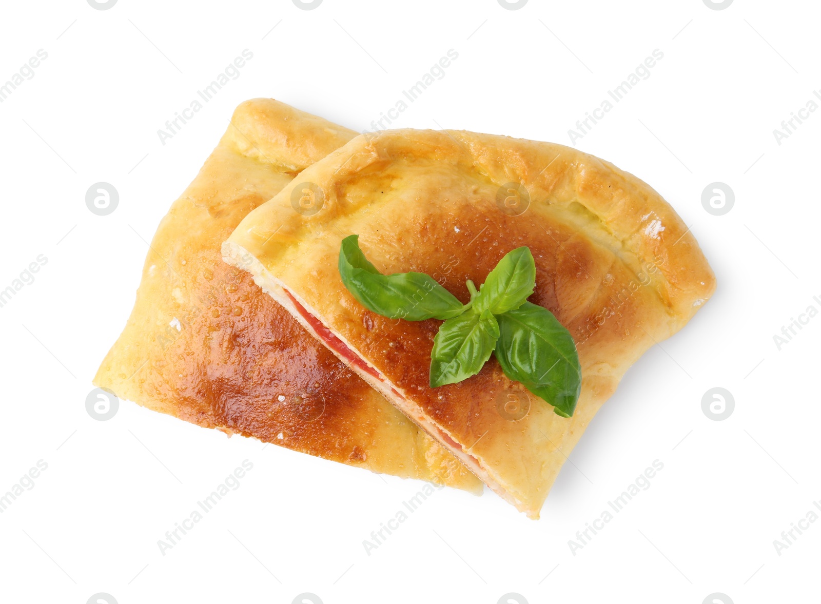 Photo of Pieces of tasty vegetarian calzone with basil isolated on white, top view