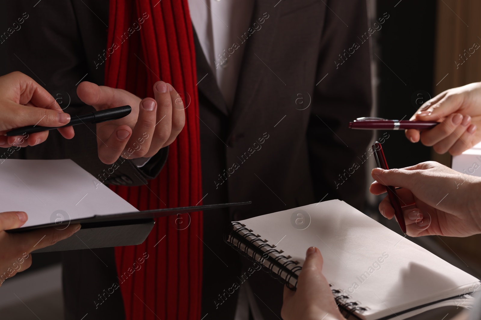 Photo of Man signing autograph in book on dark background, closeup