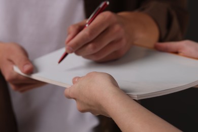 Photo of Man signing autograph in notebook, closeup view