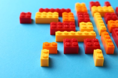 Photo of Constructor toy. Many colorful building blocks on light blue background, closeup