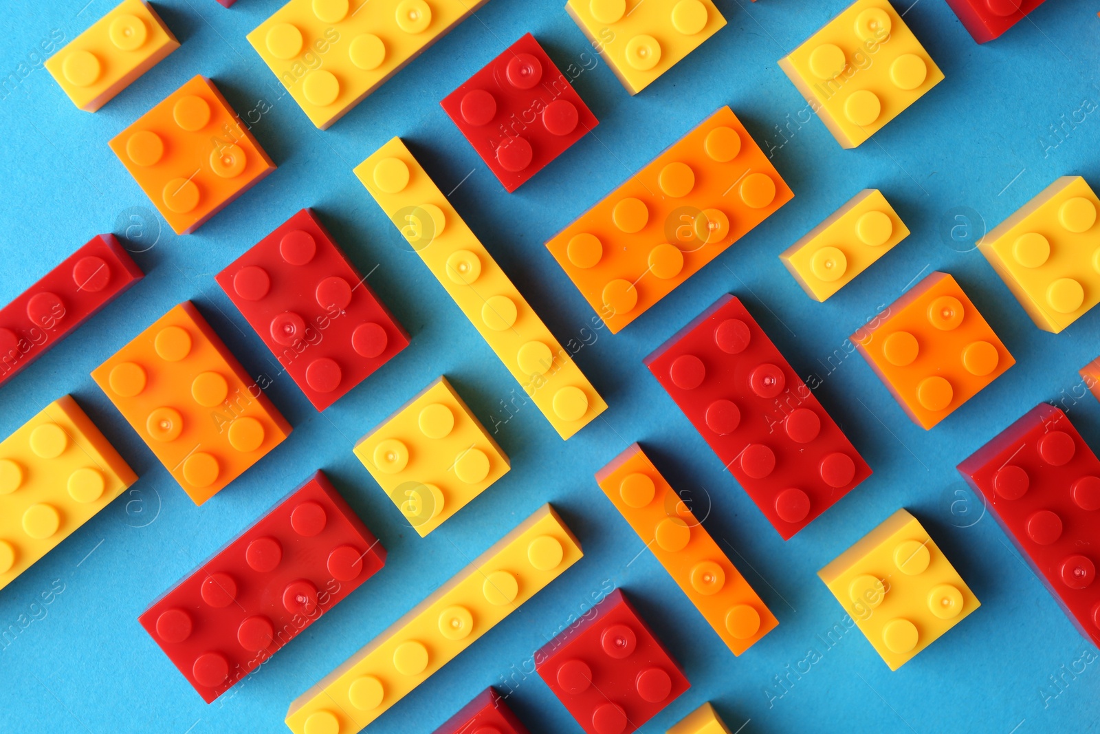 Photo of Constructor toy. Many colorful building blocks on light blue background, flat lay