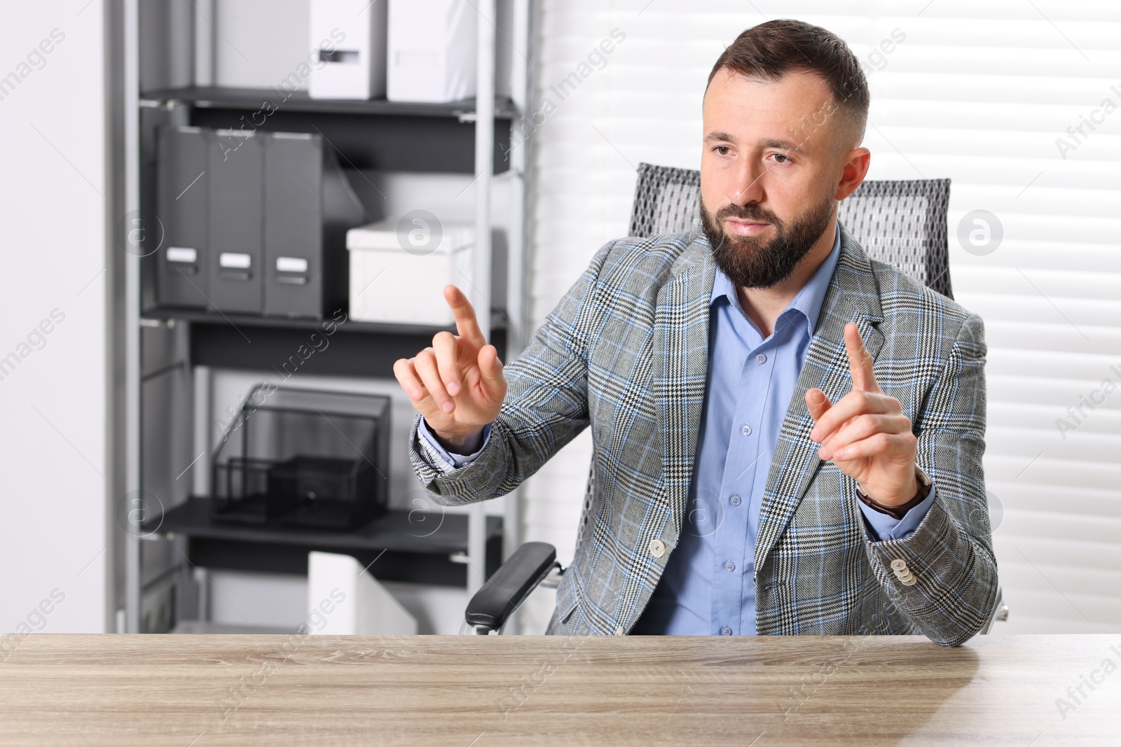 Photo of Man showing something at wooden desk in office, space for text