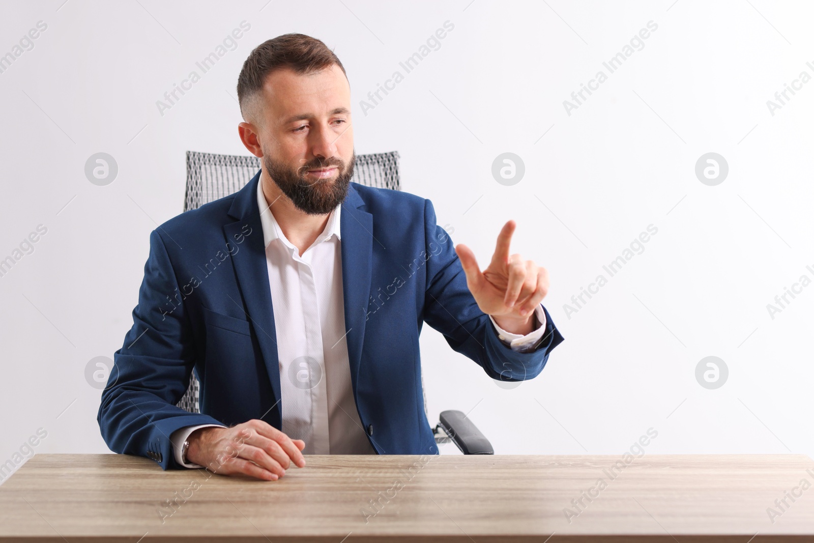 Photo of Man pointing at something at wooden desk in office, space for text