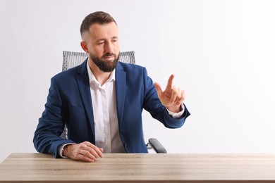 Man pointing at something at wooden desk in office, space for text