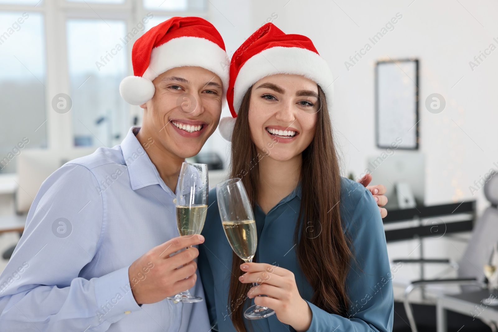 Photo of Happy coworkers clinking glasses of wine during office Christmas party