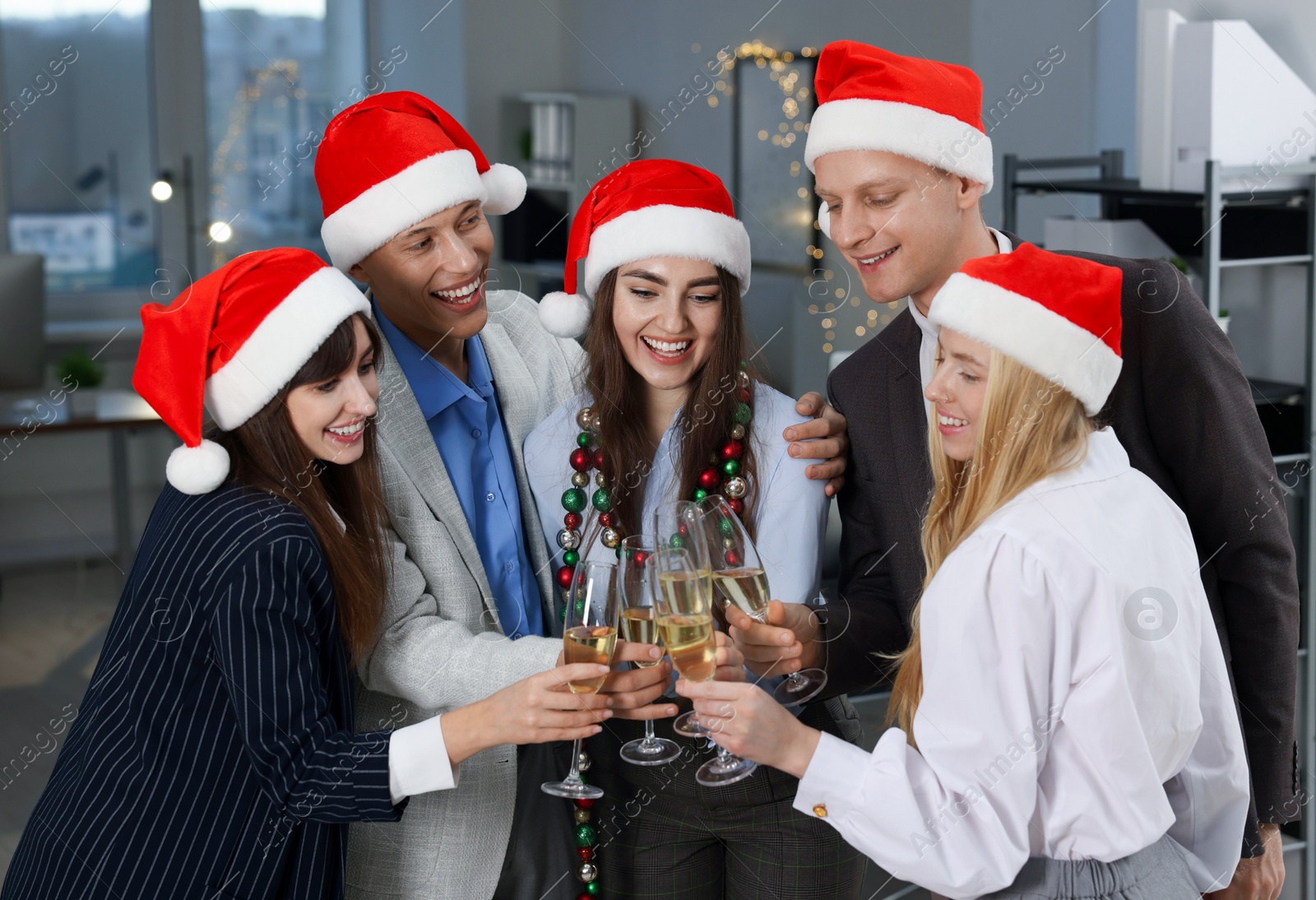 Photo of Happy coworkers clinking glasses of wine during office Christmas party