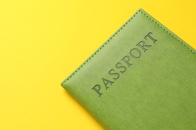 Photo of Passport in green cover on yellow background, closeup. Space for text