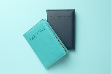 Photo of Passports in color covers on light blue background, top view