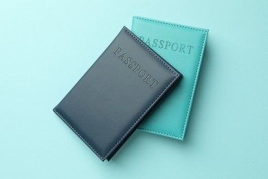 Photo of Passports in color covers on light blue background, top view