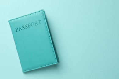 Photo of Passport in bright cover on light blue background, top view. Space for text