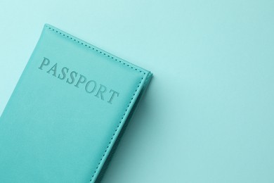 Photo of Passport in bright cover on light blue background, top view. Space for text