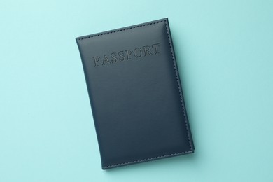 Photo of Passport in bright cover on light blue background, top view