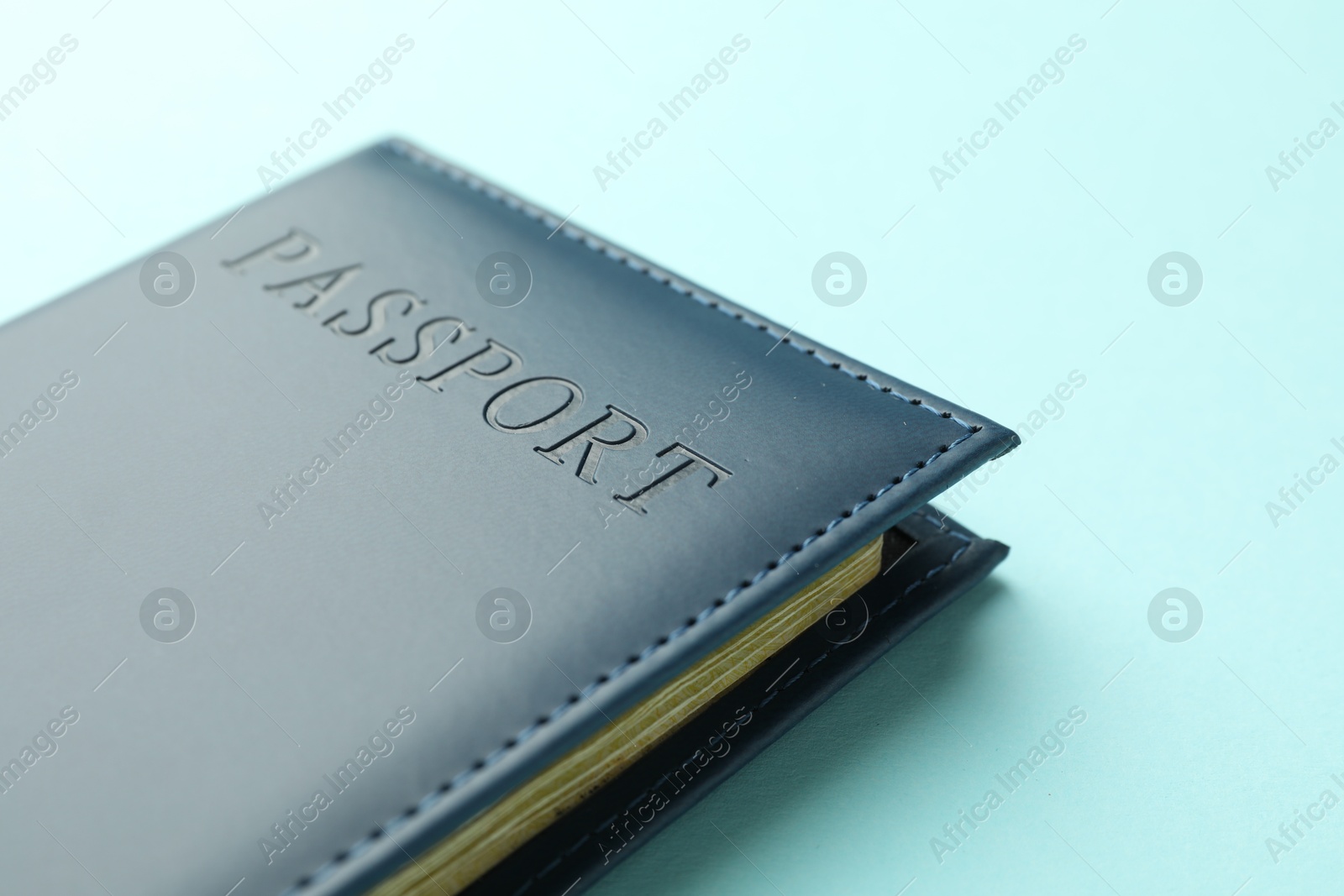 Photo of Passport in bright cover on light blue background, closeup