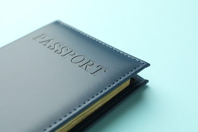 Photo of Passport in bright cover on light blue background, closeup