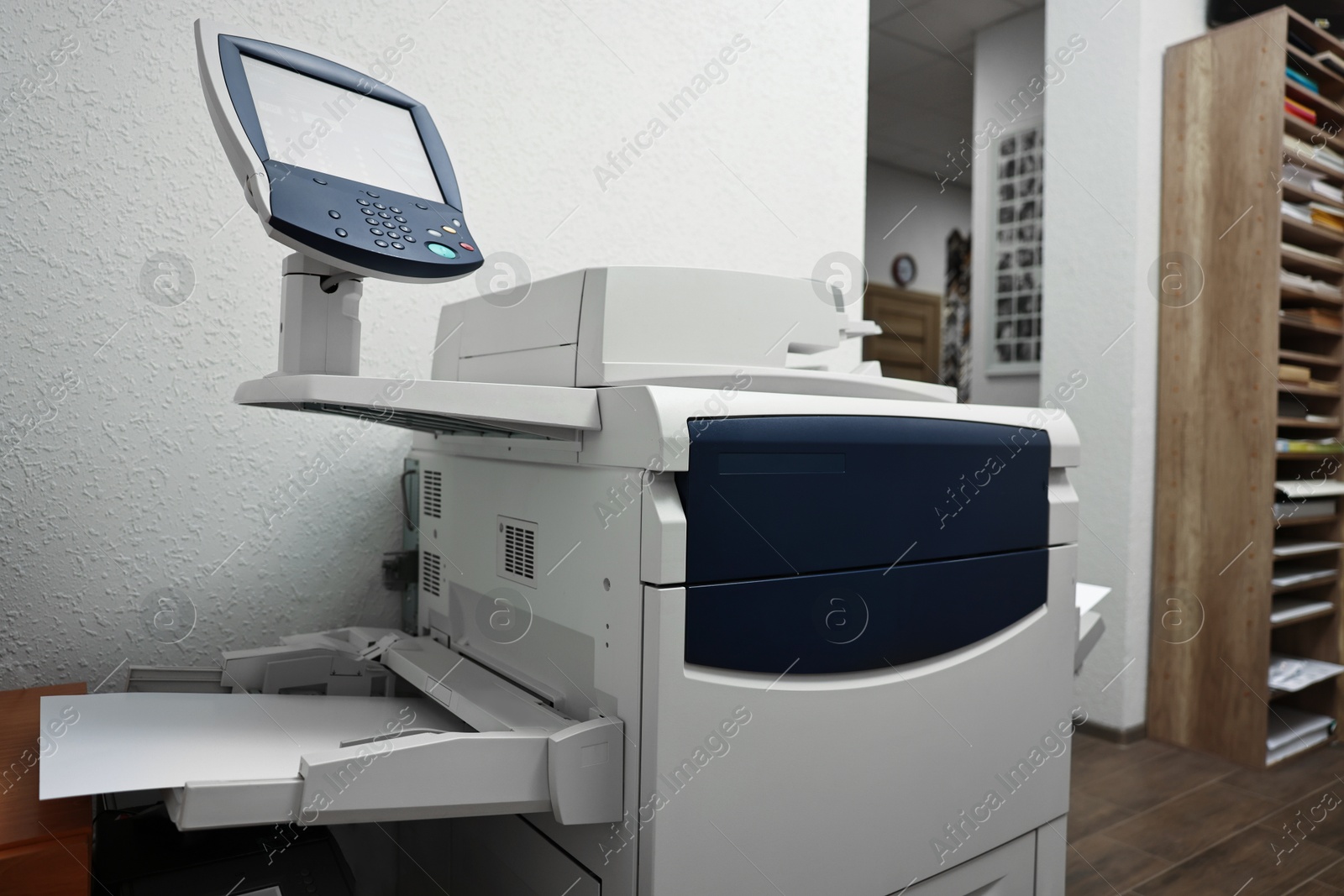 Photo of Modern printer with paper indoors. Printing house