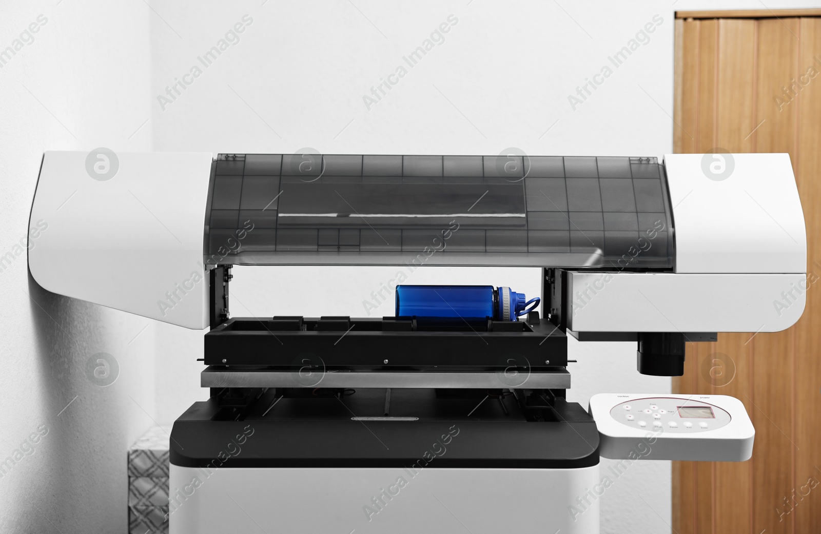 Photo of Modern printer and empty bottle in room