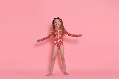 Photo of Happy girl in beachwear and sunglasses on pink background