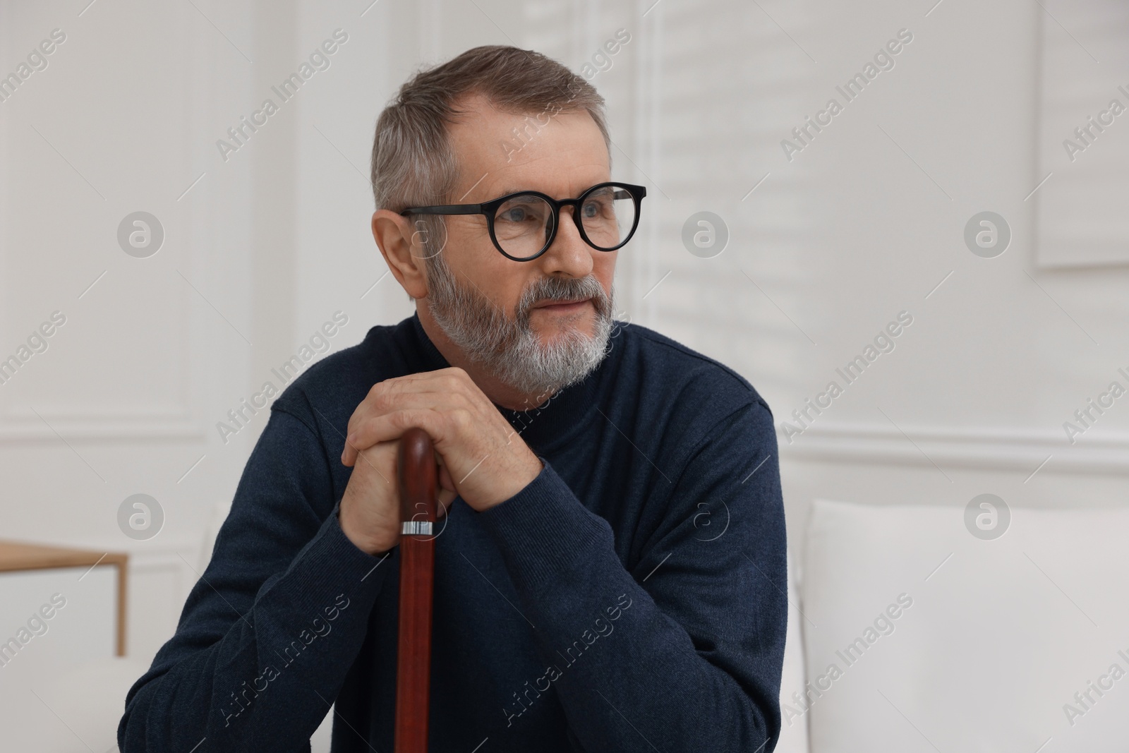 Photo of Mature man with walking cane at home