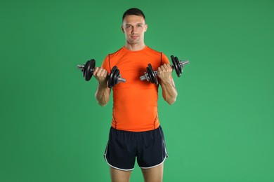 Photo of Man exercising with barbells on green background