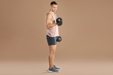 Man exercising with barbells on light brown background