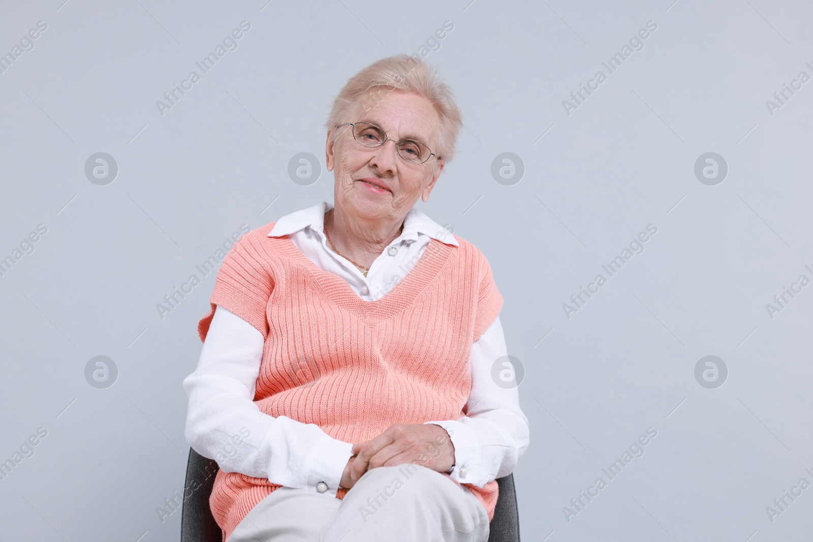 Photo of Senior woman on chair against light background