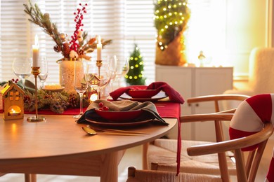 Photo of Christmas table setting with stylish dishware and festive decor indoors