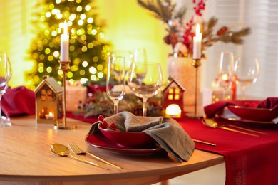 Photo of Christmas table setting with stylish dishware and festive decor indoors