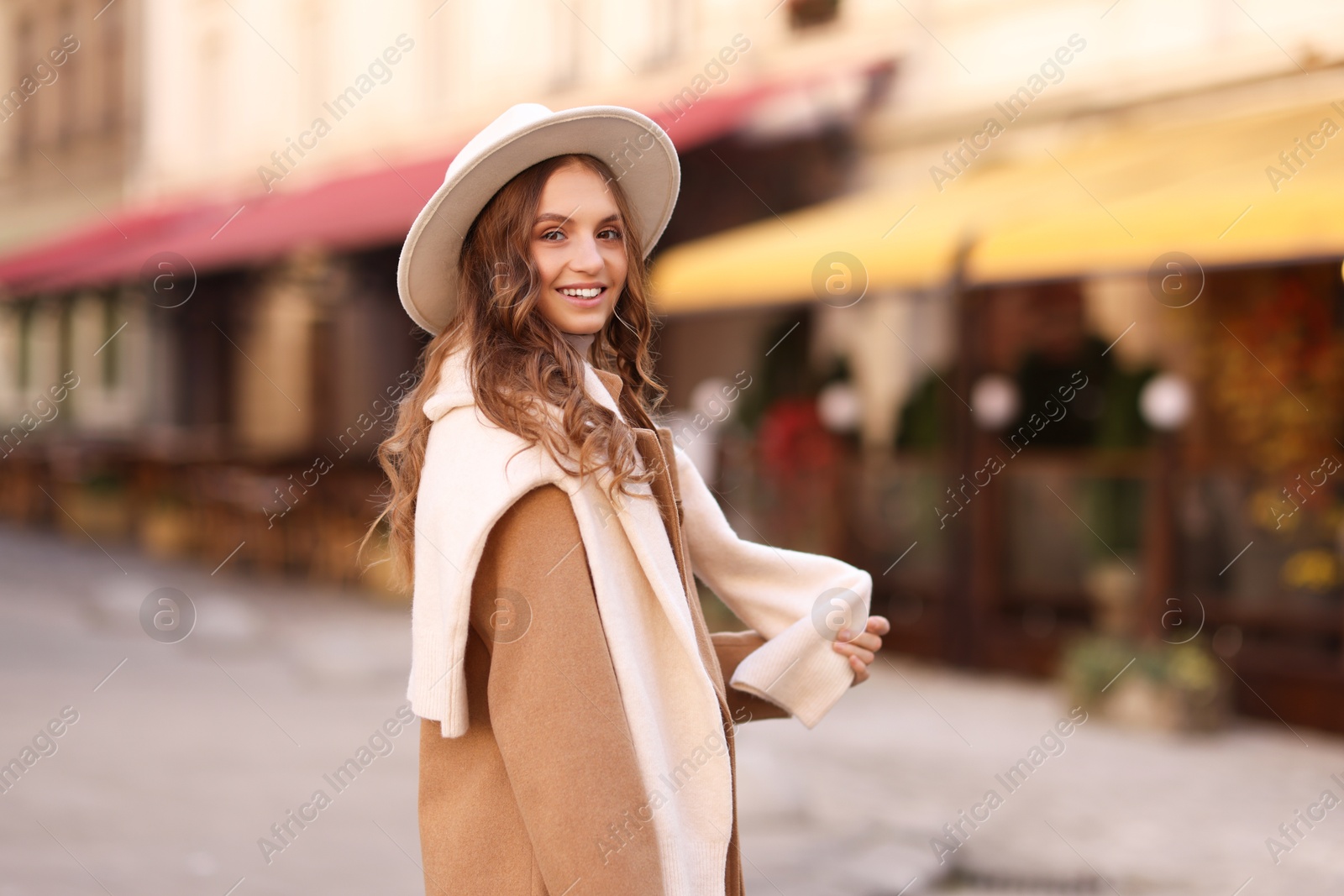 Photo of Beautiful young woman on city street. Autumn style